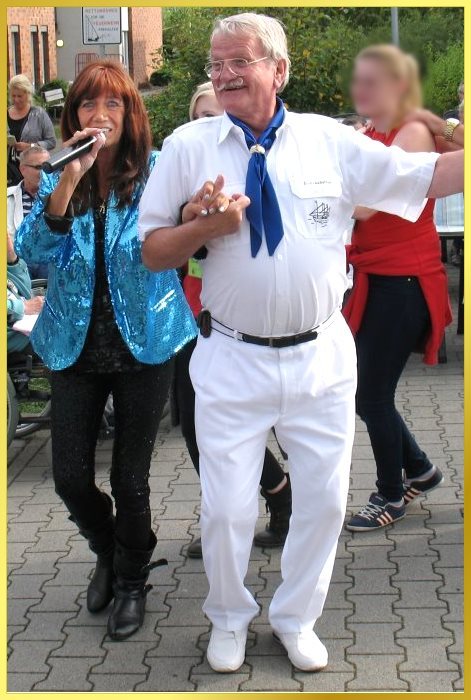 die Schlager-Piratin singend beim Leierkastenmann Curtinus untergehakt.